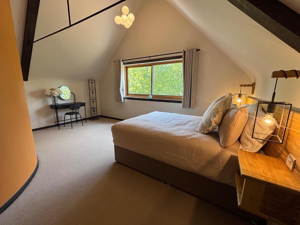 a bedroom with a bed with a window and a desk at Lime Tree House - Sleeps 12 - Hot Tub in Sudbury