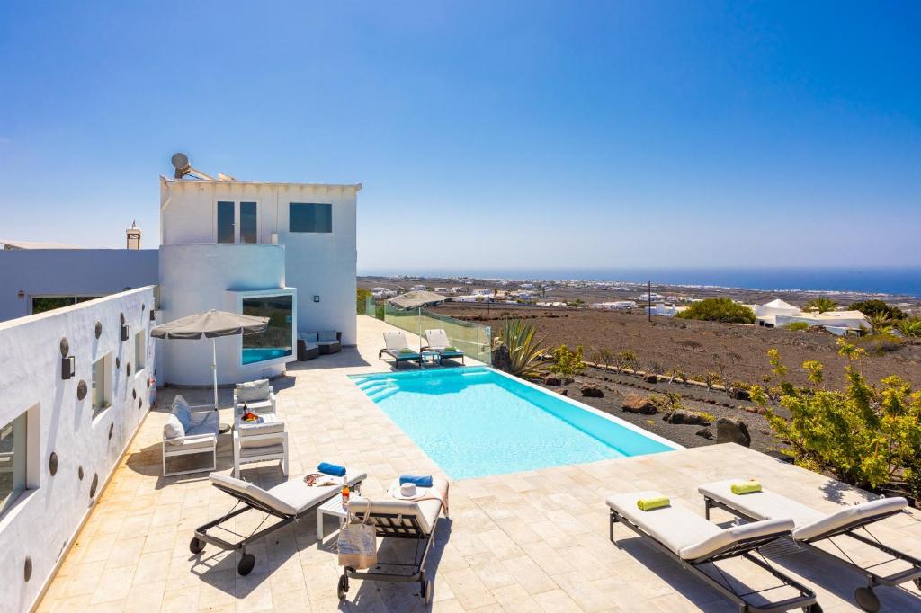 a villa with a swimming pool and the ocean at The View in Tías