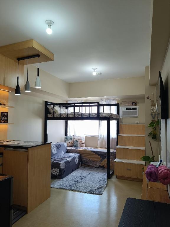 a living room with a bunk bed and a kitchen at AVIDA Aspiras Tower 2 in Cagayan de Oro