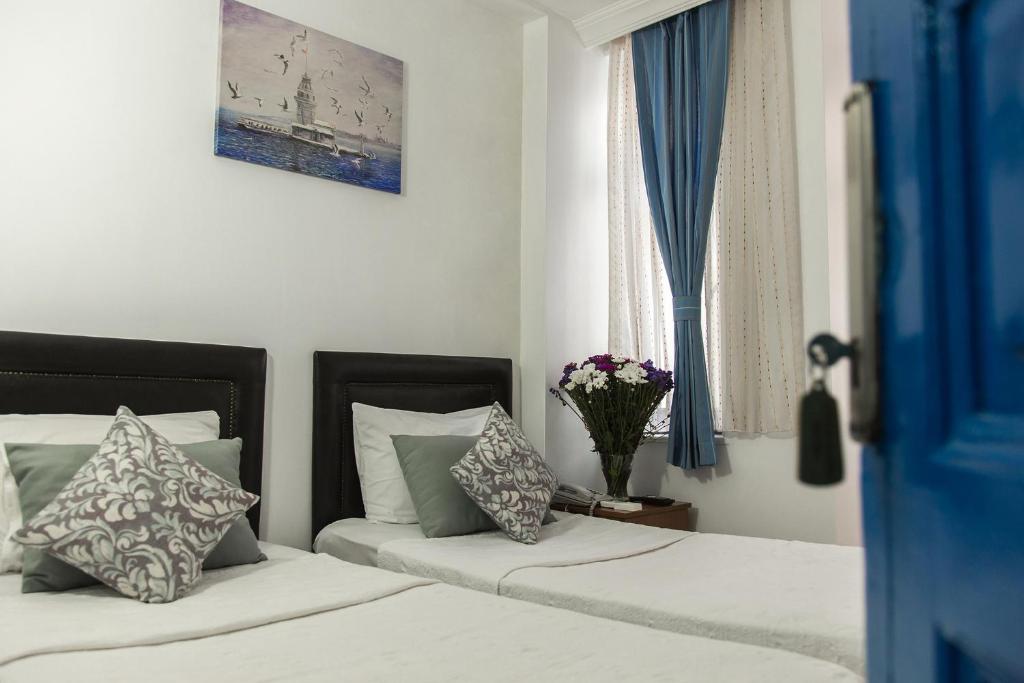 a bedroom with two beds with pillows and a window at The House of Tulpan in Istanbul