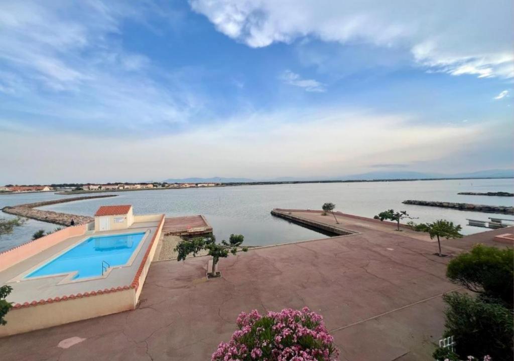 - une vue sur une étendue d'eau avec une piscine dans l'établissement Bel appartement avec vue au Barcarès, au Barcarès