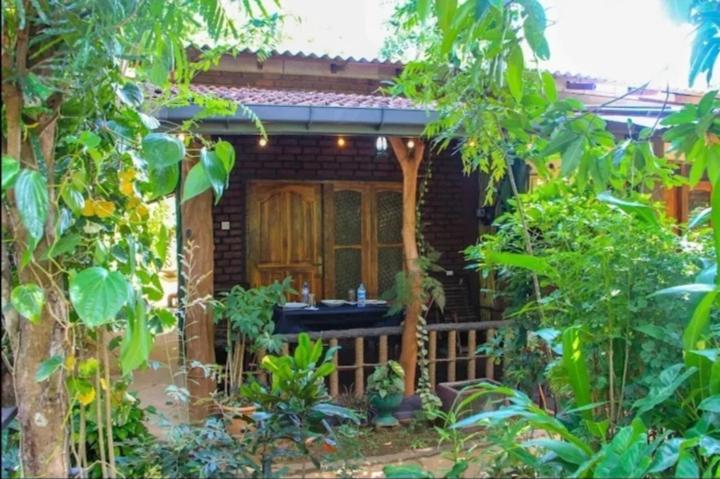 a small house with a porch in the garden at Sigiri Niwahana Home Stay in Sigiriya