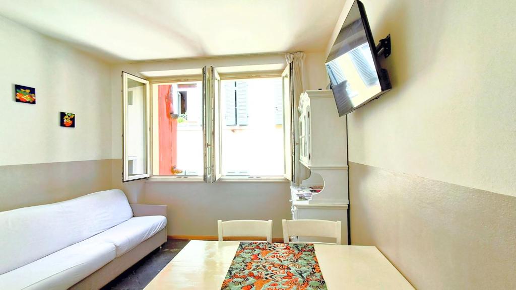a living room with a couch and a tv on the wall at STRATEGiCO CENTROSTORiCO-STAZiONE con Terrazza&Balcone in Trento