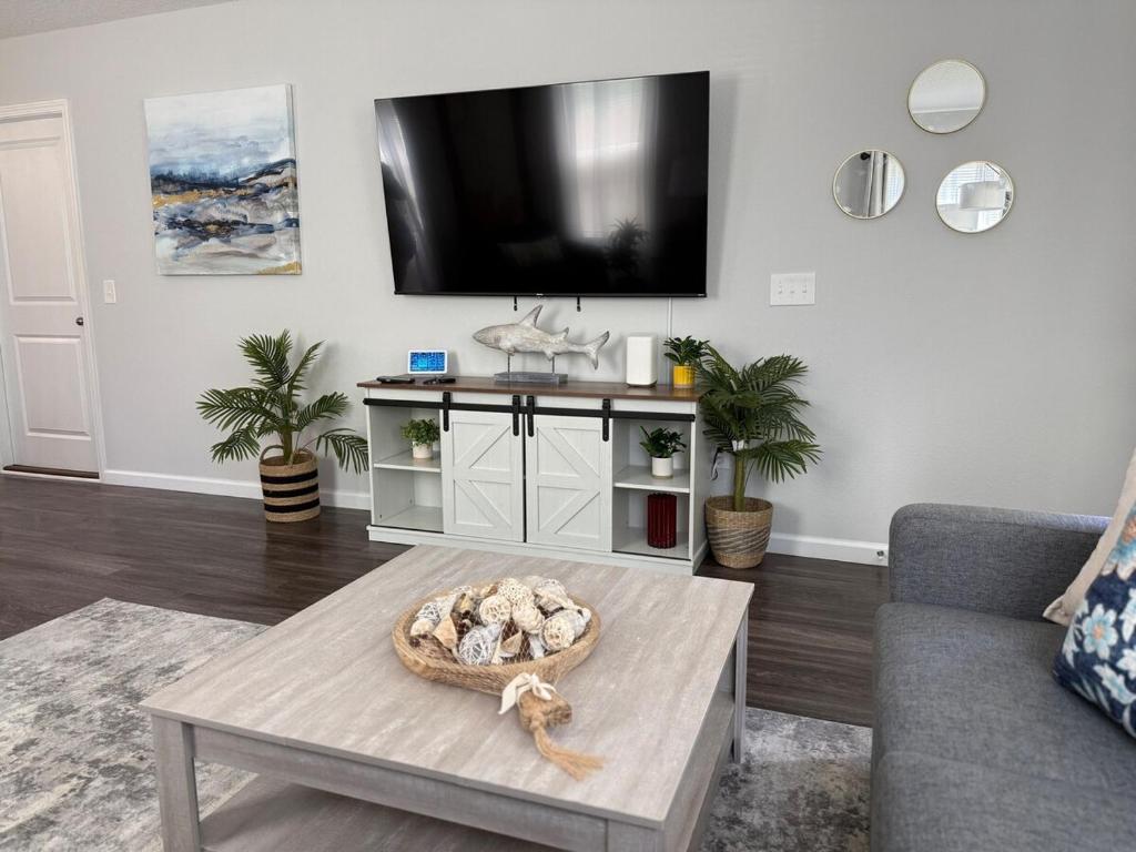 Una sala de estar con una mesa y un televisor en la pared. en The Old City Sunshine Retreat, en St. Augustine