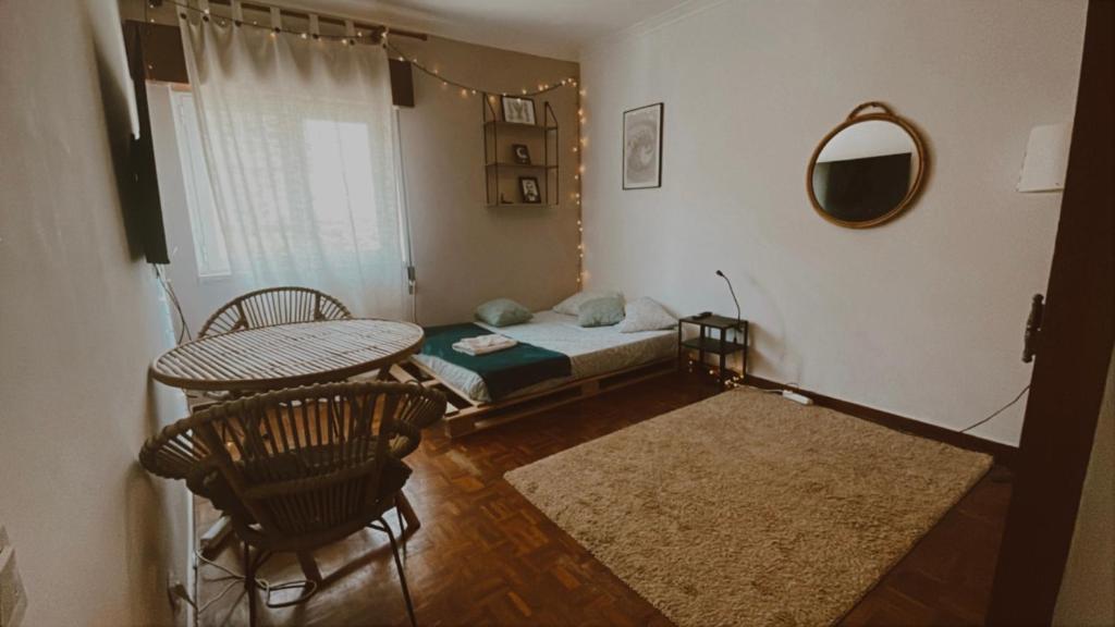 a bedroom with a bed and a table and chairs at Peaceful Boho Room in Costa da Caparica in Costa da Caparica