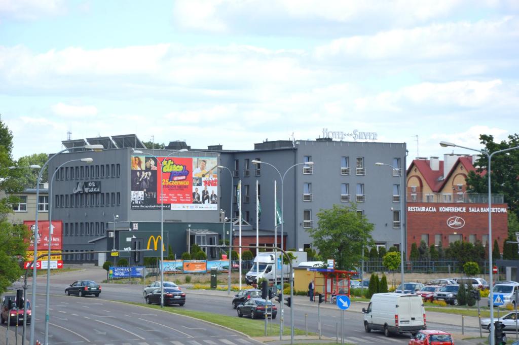 une ville avec des voitures qui descendent dans une rue avec des bâtiments dans l'établissement Silver Budget, à Białystok