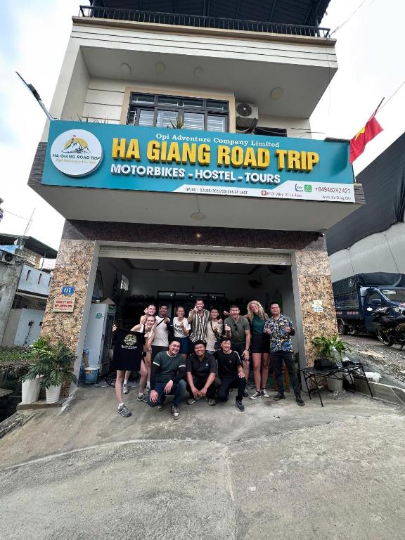 a group of people posing for a picture under a building at Opi Homestay in Làng Me