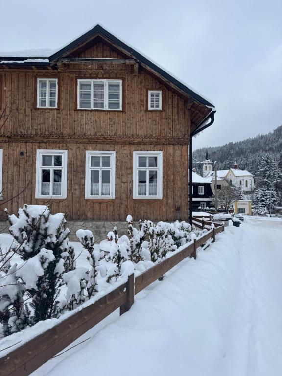 a house with snow covered plants in front of it at Chalupa JFD, Josefův Důl in Josefuv dul