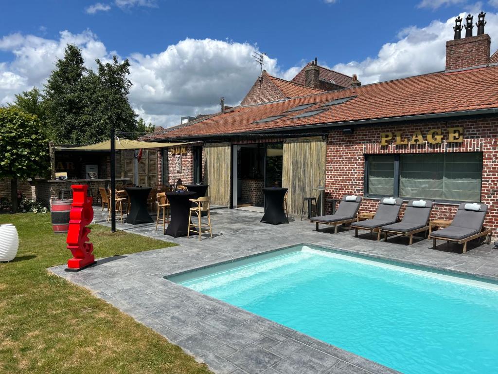 een zwembad in een tuin naast een gebouw bij Gîte à la ferme in Houplin-Ancoisne