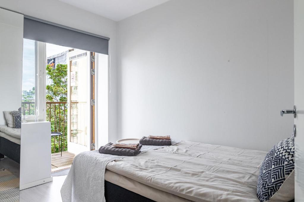 ラハティにあるModern 1BR Home with Sauna & Balconyの白いベッドルーム(ベッド1台、バルコニー付)