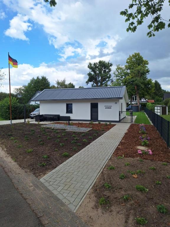 a white building with a flag in front of it at Ferienhaus Jannik in Hüde