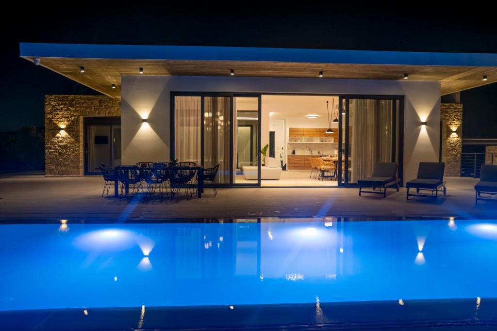 a house with a swimming pool at night at Antiope Retreat in Pitsidia