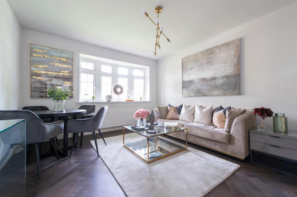 a living room with a couch and a table at Modern 2BR Flat with 3 Beds Urban Getaway - Cherry in London