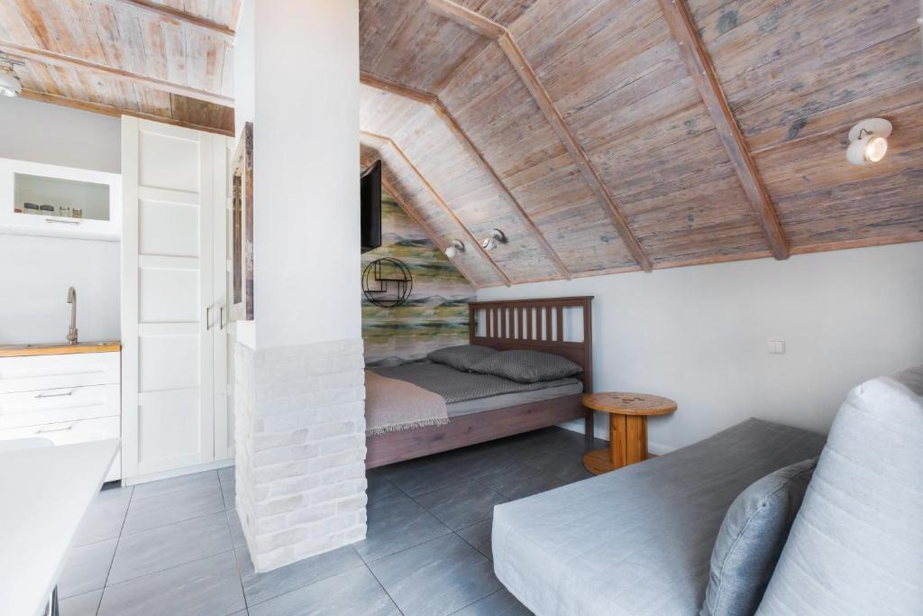 a bedroom with a bed and a wooden ceiling at Apartament z tarasem in Stegna