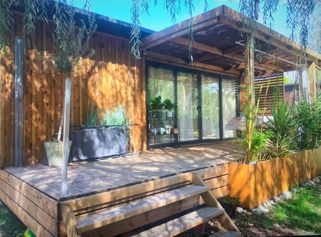 une maison avec un banc devant dans l'établissement Chalet cozy dans Village au cœur des pins, parking gratuit, à Onesse-et-Laharie