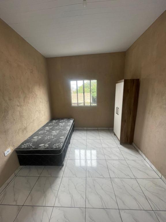 a empty room with a bed and a window at Spazzio hostel in São José dos Campos
