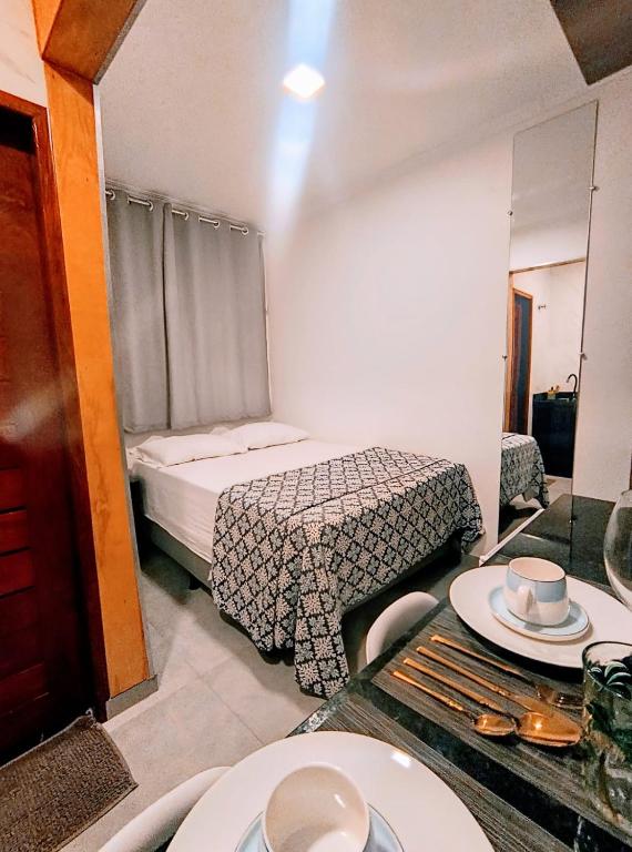 a room with a bed and a table with plates on it at UrbanStay Flats in João Pessoa