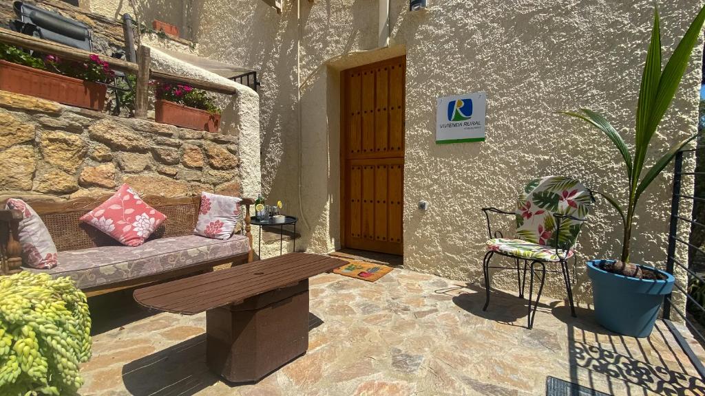 eine Terrasse mit einer Bank, einem Tisch und einer Tür in der Unterkunft Apartamento rural Casa Medico in Turre