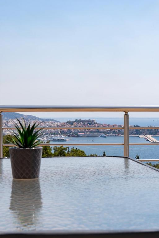 a table with a potted plant on a balcony overlooking the water at Seametry premium residencies Kavala in Kavála