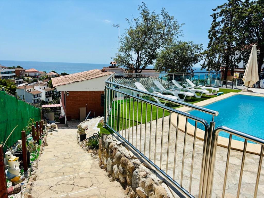 a swimming pool with lounge chairs next to a house at House with ocean and mountain views in Santa Susanna