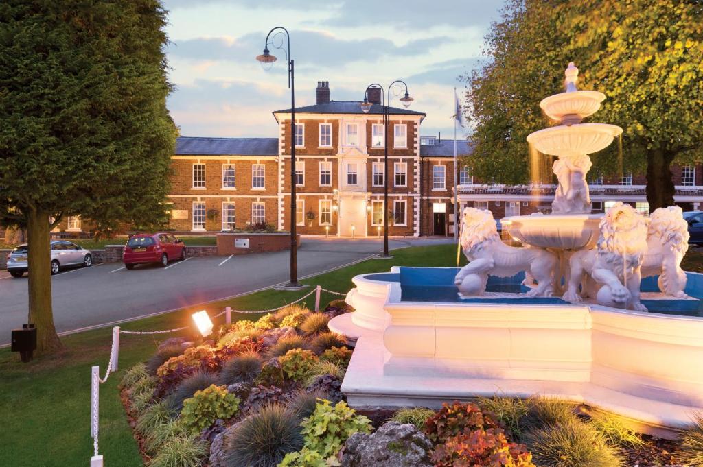 una statua di una fontana di fronte a un edificio di Park Hall Hotel and Spa Wolverhampton a Wolverhampton