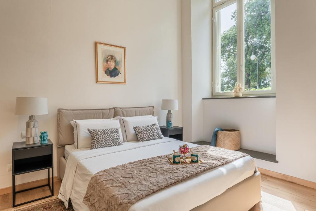 ルッカにあるVerdi Apartmentの大きなベッドと2つの窓がある寝室