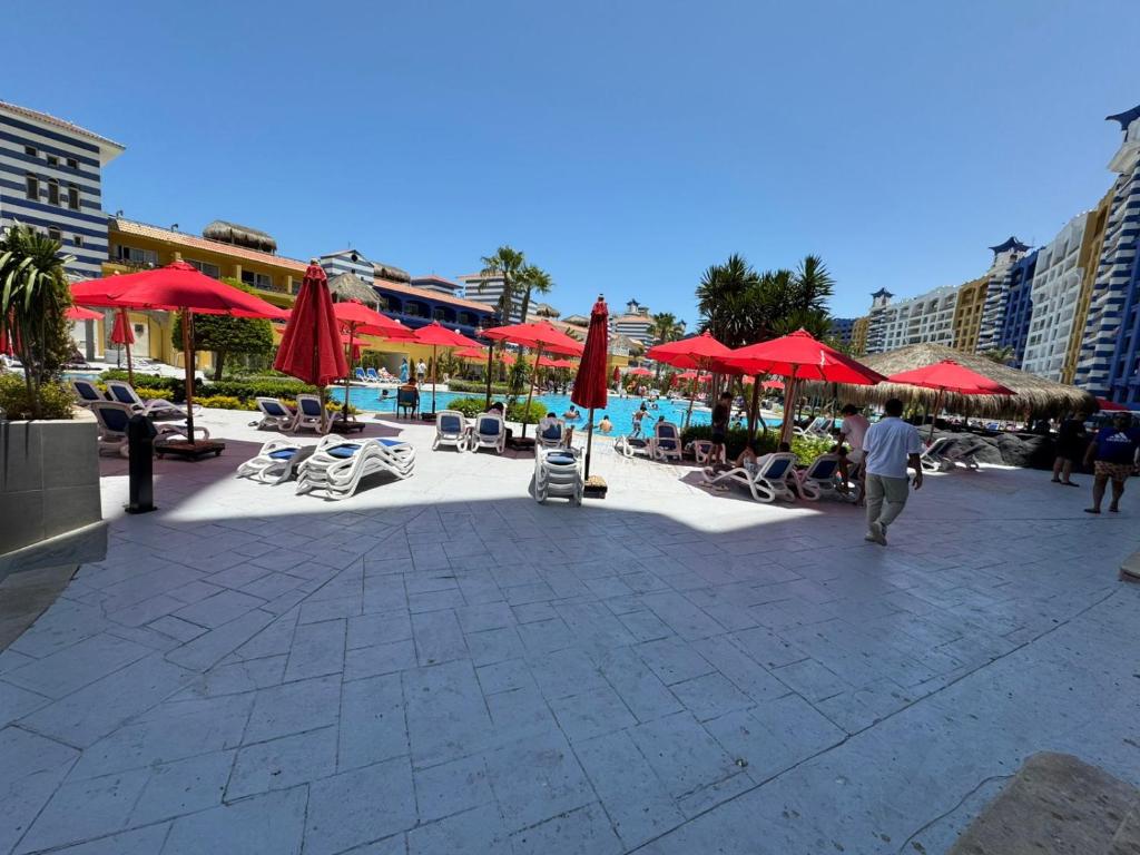 エル・アラメインにあるamazing view Patio Suite porto marina hotel بورتو مارينا باتيو سويتの赤いパラソルと椅子、プール付きのパティオ