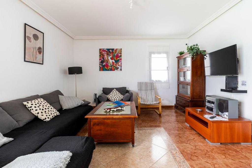 a living room with a couch and a tv at Villa Car&Melo in Nazaret