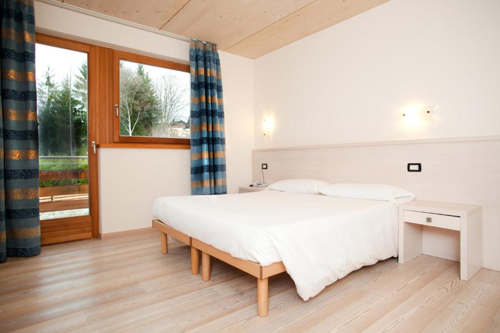 sypialnia z dużym łóżkiem i oknem w obiekcie Bio Hotel Benny w mieście Commezzadura