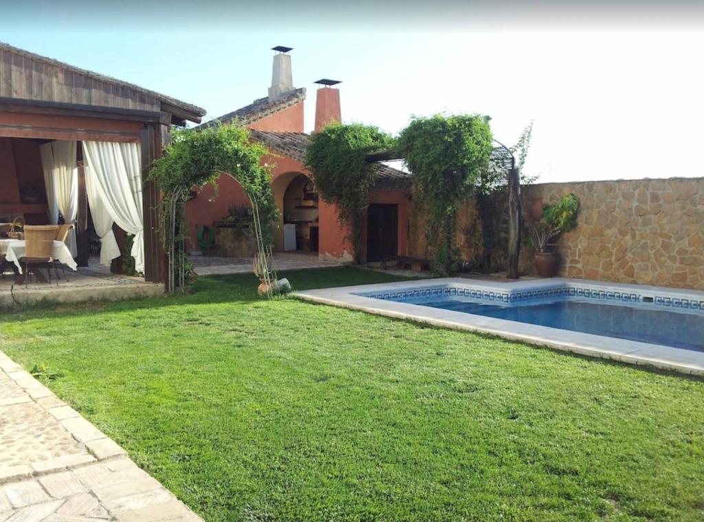 ein Hinterhof mit einem Swimmingpool und einem Haus in der Unterkunft Casa Cortijo in La Luisiana