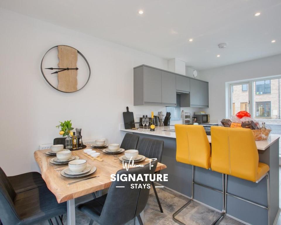 海尔Harveys Yard by Signature Stays - Hayle House - Parking - Sleeps 6的厨房以及带木桌和黄色椅子的用餐室。