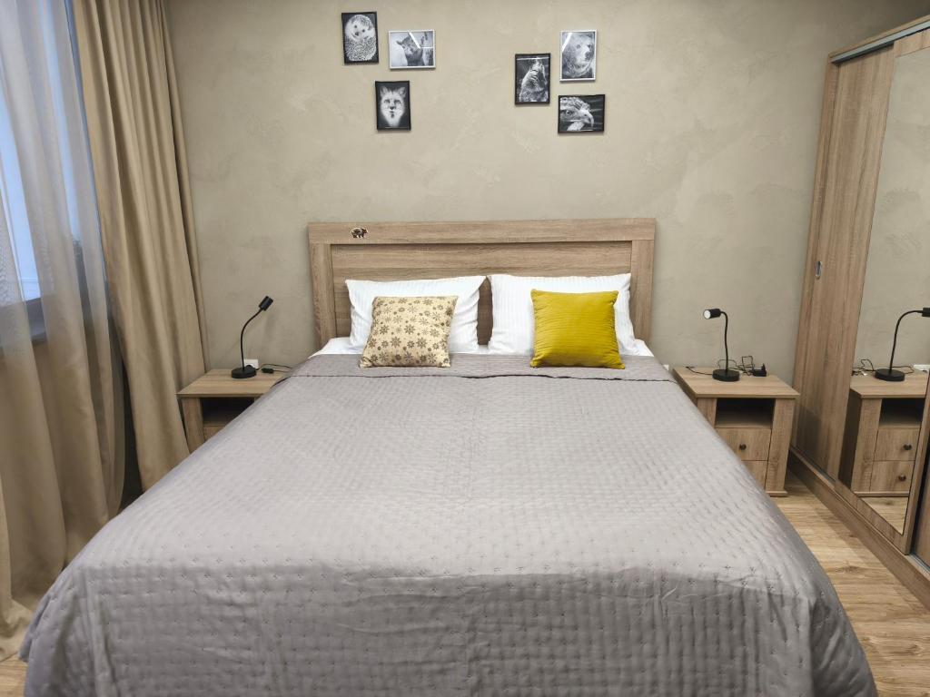 a bedroom with a bed with two lamps and pictures on the wall at Borovets Gardens Forest STUDIO A3 in Borovets