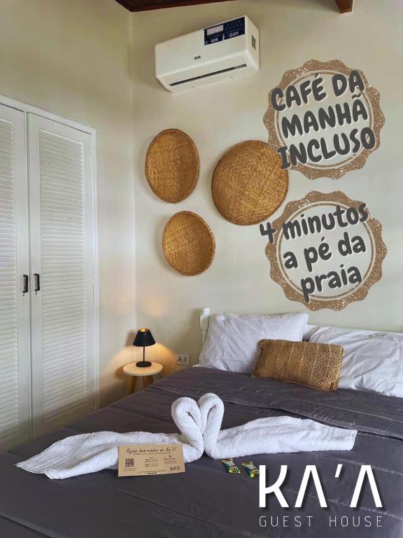 a bedroom with a bed with baskets on the wall at Ka'a Guest House in Ubatuba