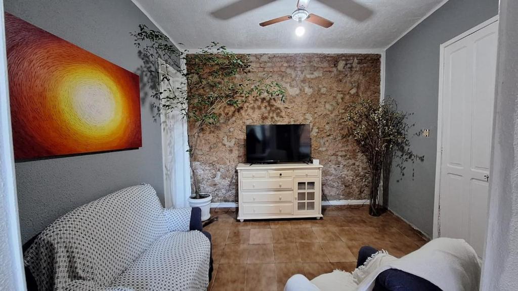un salon avec un canapé et une télévision dans l'établissement Casa com amplo quintal, a paz ao lado do Centro, à Rio de Janeiro