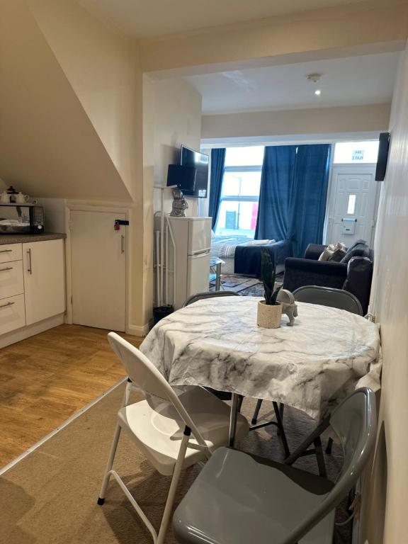 Una cocina y una sala de estar con mesa y sillas. en Eastbourne Beachfront Apartments, en Eastbourne