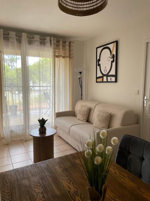 ein Wohnzimmer mit Sofa und Tisch in der Unterkunft Escapade Uzétienne Cœur de ville et Parking in Uzès