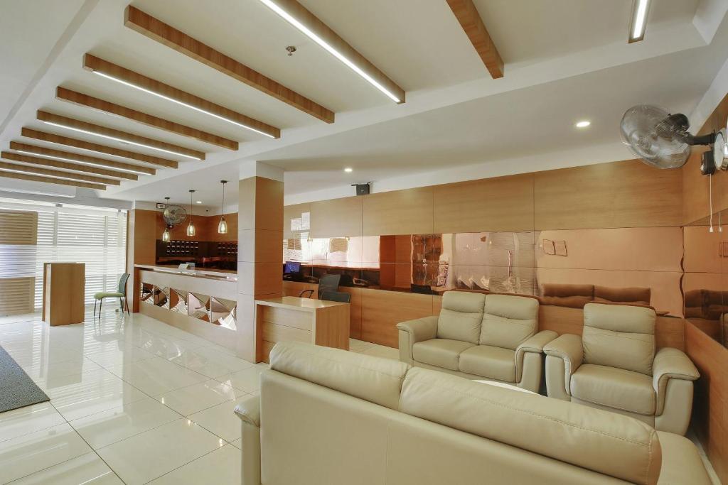a living room with a couch and two chairs at Super Townhouse Edasserys Kalamassery Tourist Home in Cochin