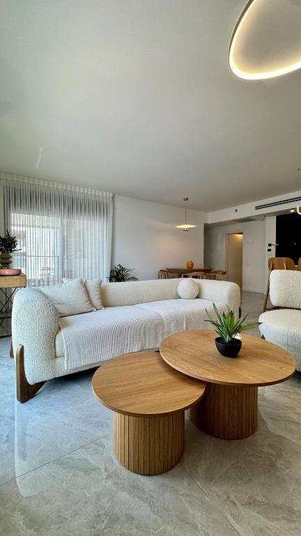 a living room with two couches and a table at Blue Bay in Netanya