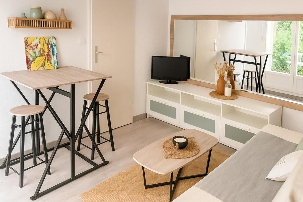 エルドゥヴァンにあるMaison de plage avec piscine Erdeven-Carnacのテーブルとテレビのあるリビングルーム