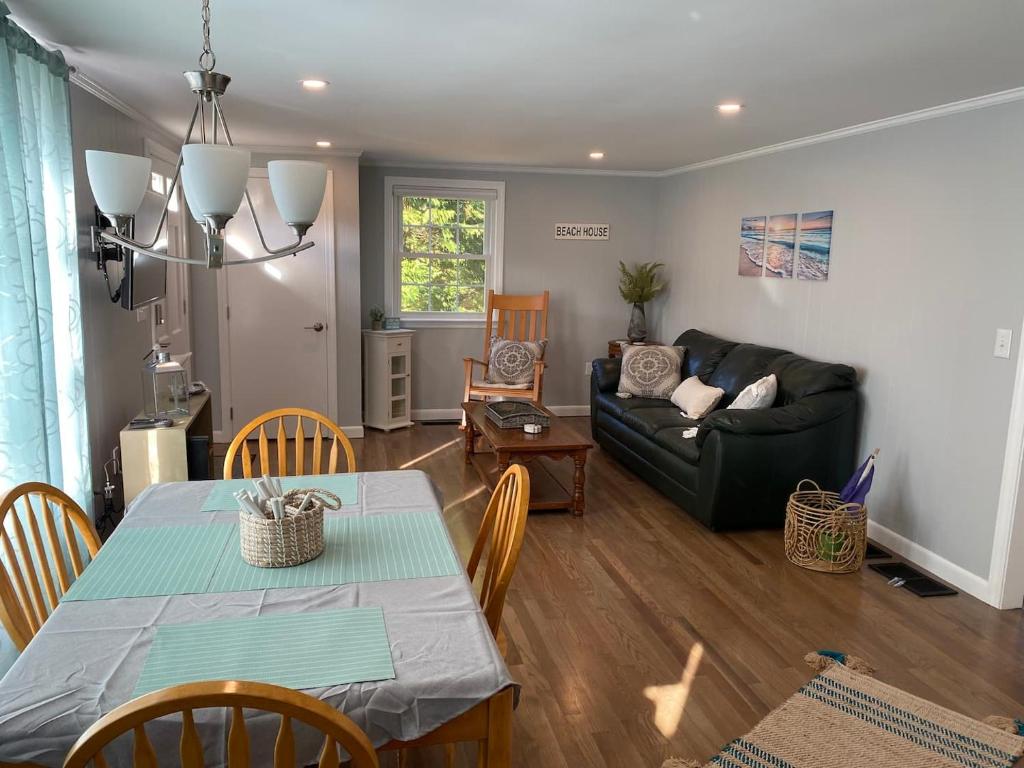 ein Wohnzimmer mit Tisch und Couch in der Unterkunft Willows Cottage East in Dennis Port