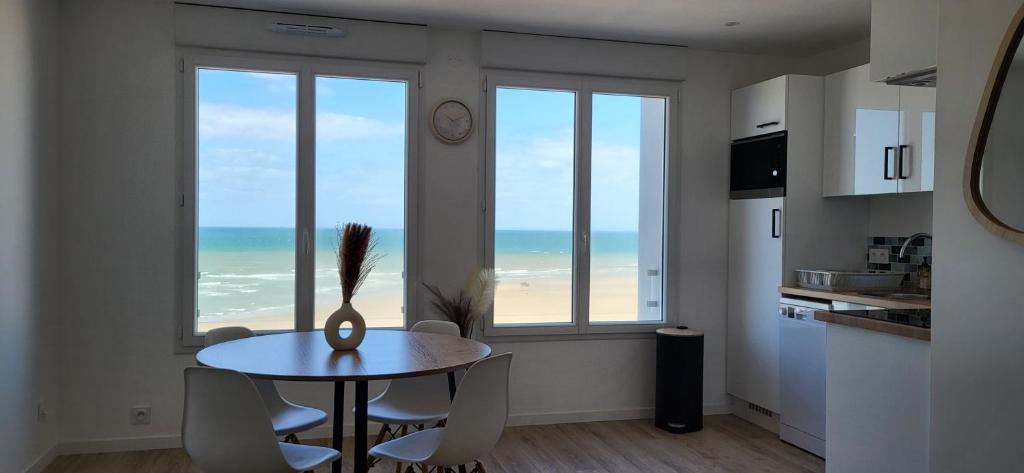 a dining room with a table and a view of the ocean at L'écume du fort , Face à la mer, Coucher de soleil in Le Portel