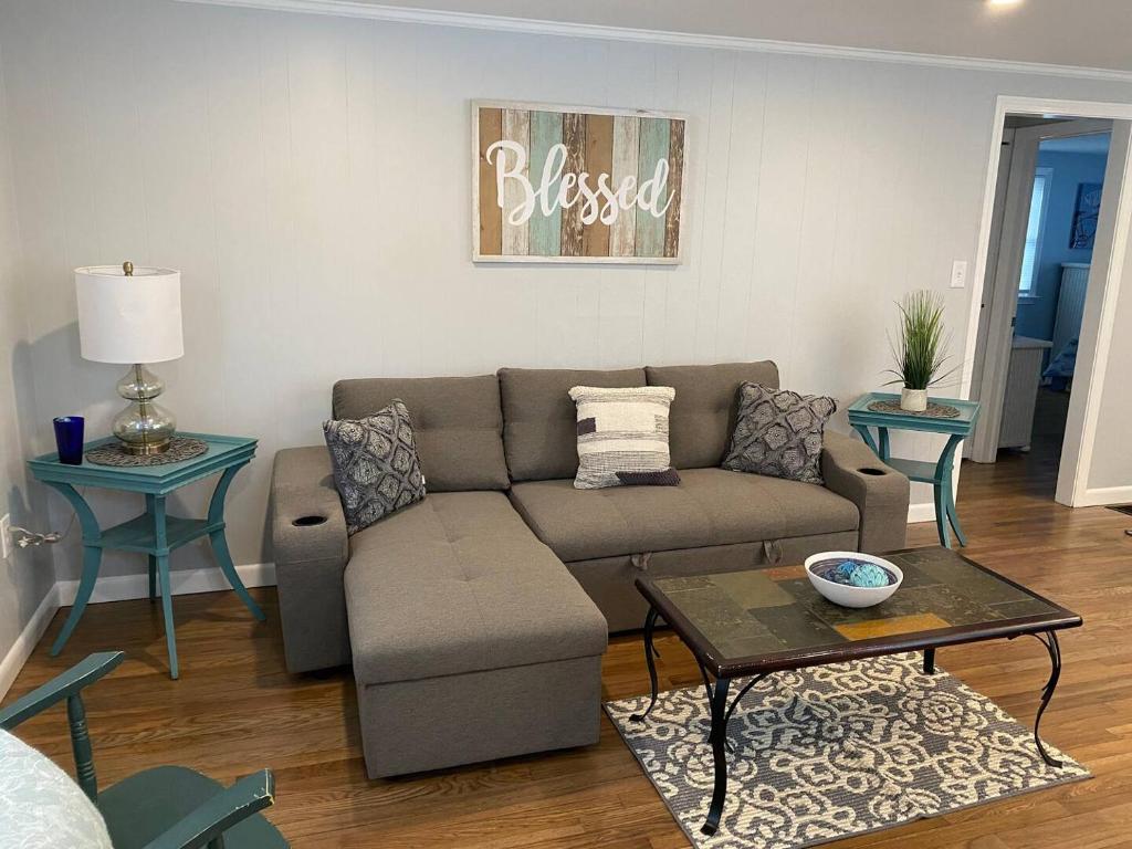 ein Wohnzimmer mit Sofa und Tisch in der Unterkunft Willows Cottage West in Dennis Port