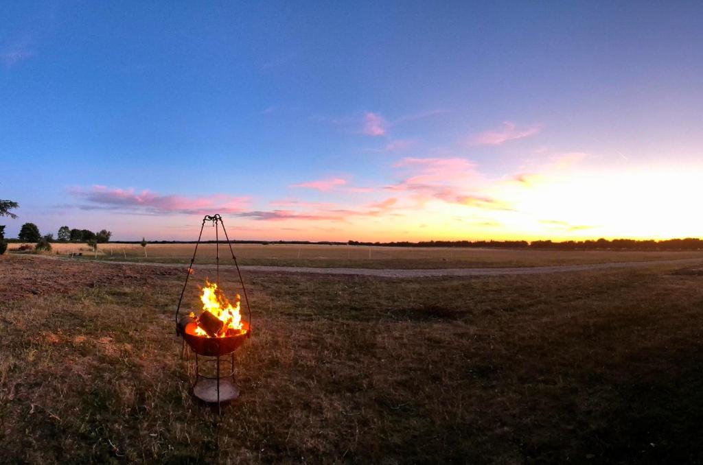 a fire pit in a field at sunset at The Cosy Hide - A romantic rural retreat for 2 in Cottenham