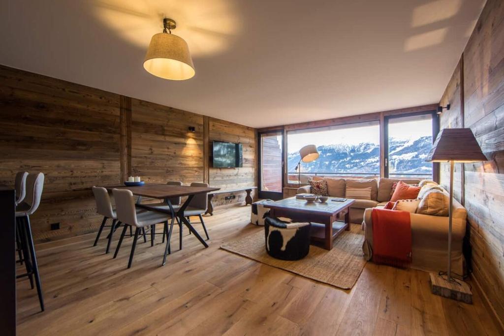 a living room with a couch and a table at La Ruinette-stylish 2-bed With Pool & Gym Access in Verbier
