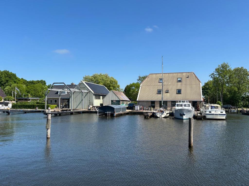 a marina with boats docked next to a building at Waterzicht 3 in Uitwellingerga