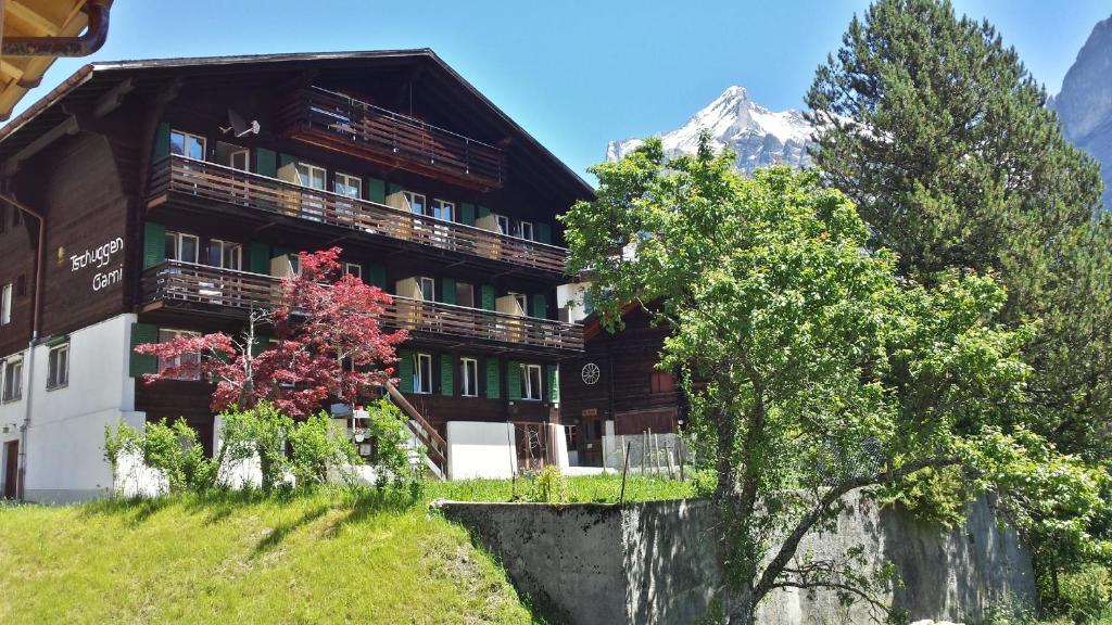 ein großes Holzgebäude mit einem Berg im Hintergrund in der Unterkunft Hotel Tschuggen in Grindelwald