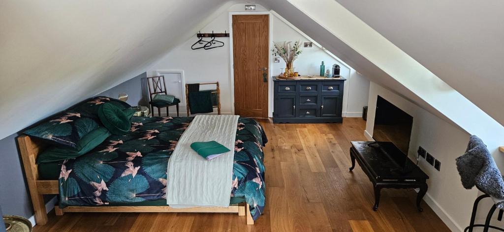 a bedroom with a bed and a staircase at White Cottage Loft in Newtown Limford