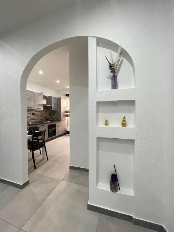 a living room with a white wall with shelves at La Viuzza Rooms in Barletta