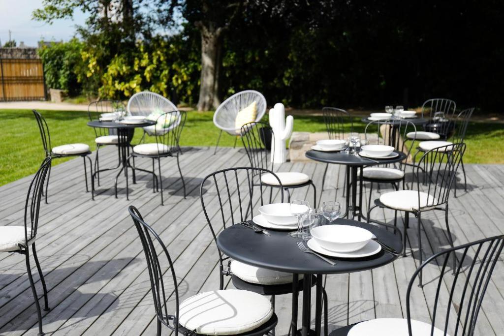un groupe de tables et de chaises sur une terrasse dans l'établissement Résidence L' Aristide - Appartement Aretha, à Auray