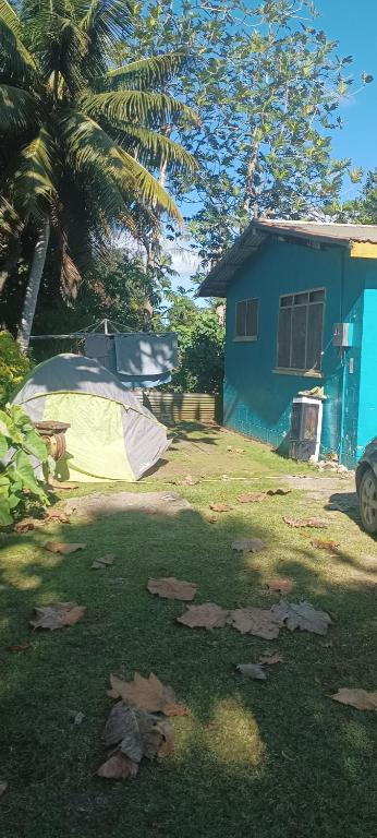a yard with a tent in front of a house at Buddle Camping Ground in Nuku‘alofa